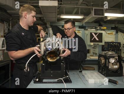 Mer Méditerranée (18 juin 2017) Technicien en électronique de l'Aviation 3e classe Kevin Beales, gauche, et technicien en électronique de l'Aviation 2e classe Cody peu de travail sur la voie à suivre (FLIR) unité à bord du porte-avions USS George H. W. Bush (CVN 77) (GHWB). GHWB, une partie de la George H. W. Groupe aéronaval du Bush (GHWBCSG), mène des opérations navales dans la sixième flotte américaine zone d'opérations à l'appui de la sécurité nationale des États-Unis en Europe et en Afrique. Banque D'Images