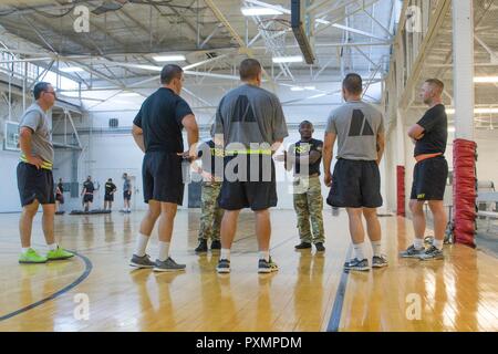 Le Sgt. Ryan Mangue, un total de formation de soldat de l'armée américaine, indique à l'entraîneur des soldats de la réserve avec la 96e Brigade de maintien de la flexibilité et de gymnastique, le 12 juin 2017, dans le centre de fitness, Ogden, Utah. L'équipe de FEP est constitué de sept athlètes olympiques de l'armée. Banque D'Images