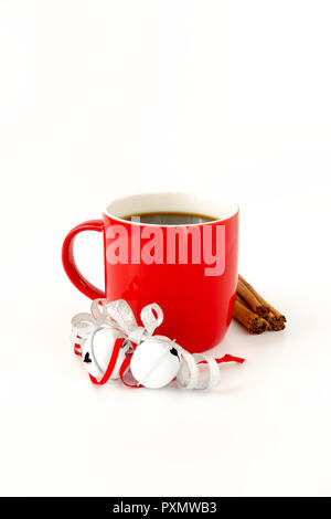 Mug rouge remplie de café noir et rehaussé de Jingle bells, ruban argent métallique, des bâtons de cannelle isolé sur fond blanc. Banque D'Images