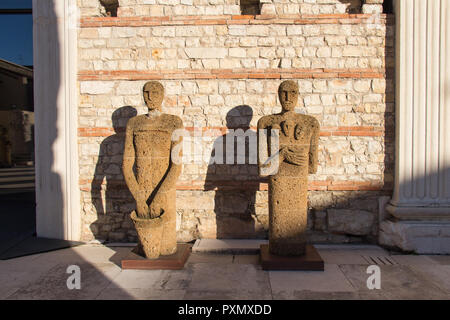 L'Italie, Brescia - 24 décembre 2017 : le point de vue de tuf Sculptures Testimoni ou témoins par l'artiste italien Mimmo Paladino à l'intérieur de la zone archéologique Banque D'Images