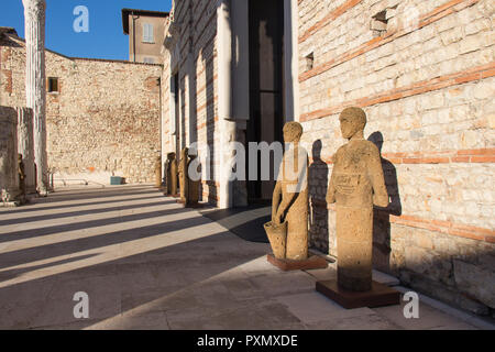 L'Italie, Brescia - 24 décembre 2017 : le point de vue de tuf Sculptures Testimoni ou témoins par l'artiste italien Mimmo Paladino à l'intérieur de la zone archéologique Banque D'Images