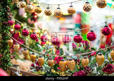 La pendaison des décorations de Noël et Nouvel An - boules rouges et or sur le marché de l'arrière-plan flou. Soft focus sélectif, copy space Banque D'Images