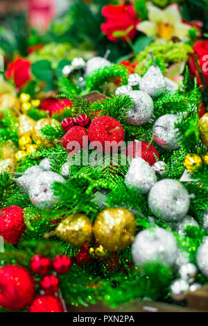 Close up Noël Décoration décoratif rouge brillant d'or et d'argent, pommes (Malus), les poires et les branches de sapin. La décoration intérieure. Bouquet d'hiver. Ver Banque D'Images