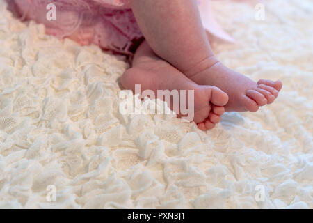 Pieds de bébé sur couverture blanche Banque D'Images
