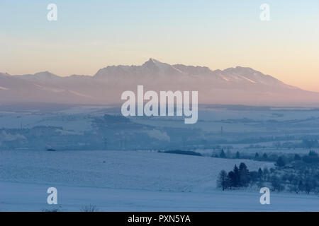 Vue panoramique des champs couverts de neige et le lever du soleil dans les Hautes Tatras, en Slovaquie. Banque D'Images