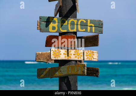 Un panneau avec écrit dessus Plage de l'océan tropical avec en arrière-plan sur un après-midi ensoleillé Banque D'Images