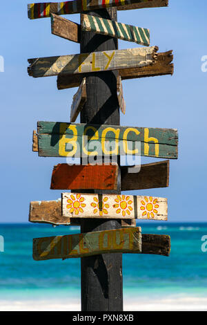 Un panneau avec écrit dessus plage tropicale avec plage et l'océan en arrière-plan sur un après-midi ensoleillé Banque D'Images