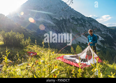 Autriche, Tyrol, randonneur mise en place sa tente sur la montagne Banque D'Images