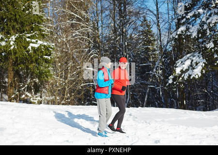 Senior Actif en forêt en hiver neige le matin Banque D'Images