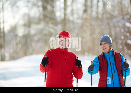 Couple en hiver ski de randonnée ou de vêtements dans la forêt aux loisirs Banque D'Images