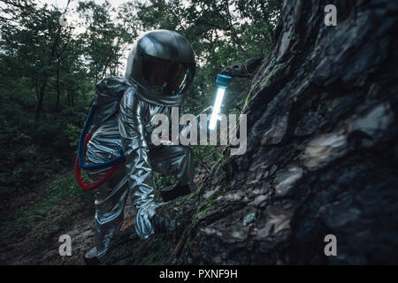 Spaceman explorer la nature, à l'aide d'un chalumeau Banque D'Images
