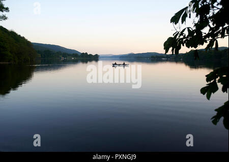 Pêcheurs dans une barque sur l'eau de Coniston le Parc National du Lake District, au crépuscule, Cumbria, England, UK, FR Banque D'Images