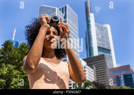 Allemagne, Francfort, portrait de jeune femme à prendre des photos dans la ville Banque D'Images