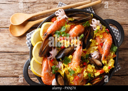 La Paella espagnole aux crevettes, moules, poissons, et le bébé octopus close-up dans une poêle sur la table supérieure horizontale. Vue de dessus Banque D'Images