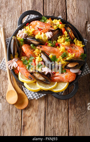 Libre de la Paella espagnole traditionnelle avec des fruits de mer dans une casserole sur la table. Haut Vertical Vue de dessus Banque D'Images