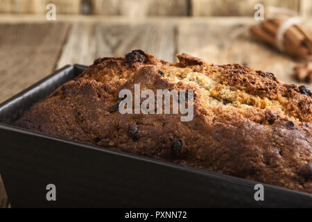 Gâteau de Noël au four avec de la cannelle, noix et fruits secs en pain sur table rustique de fête Banque D'Images