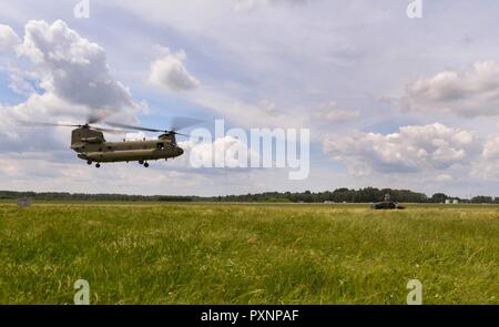 L'Armée américaine Un hélicoptère CH-47 Chinook vole vers l'US Air Force Airmen affecté à la 435ème Groupe le plan d'intervention de la 435ème Escadre d'opérations air-terre hors de Base aérienne de Ramstein, en Allemagne, au cours de l'effort de grève 17 Sabre à Lielvarde Air Base, Lettonie, 10 juin 2017. 11 000 militaires des États-Unis et de l'OTAN et 20 pays ont participé à l'exercice du 28 mai au 24 juin tout au long de diverses régions dans la région de la Baltique et de la Pologne. Banque D'Images