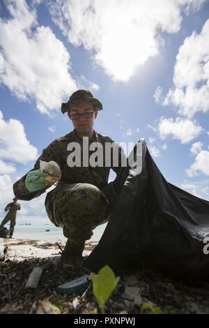 L'ÎLE Betio, Tarawa, Kiribati ATOLL- lance le Cpl. Trevor Herren picks up trash au cours d'un nettoyage de plage, le 14 juin 2017, sur l'Île Betio, Tarawa, Kiribati Atoll. Le nettoyage a eu lieu sur deux sites de la bataille de Tarawa, y compris les sections de l'un des premiers sites d'atterrissage. Herren, un Détroit, Michigan, est un spécialiste de l'embarquement avec le Siège, l'entreprise de logistique de combat 3, 3e Régiment de la logistique maritime, Groupe III Marine Expeditionary Force, actuellement à 17. Moana Koa Banque D'Images