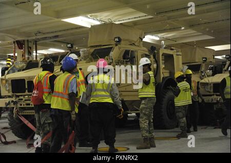 Les civils et les soldats de l'Armée américaine affecté à la 841e bataillon de transport sur-charge Mine-Resistant véhicules protégés sur l'embuscade Liberty liberty ship de la société Maritime Passion at Joint Base Charleston, S.C., le 15 juin 2017. Les membres de la 841e bataillon de transport mis en scène, traitées et configuré le matériel à l'appui du Marine Corps pré-positionnement et la mise en scène à travers l'Europe et l'Asie. Le 841e bataillon de transport de surface et de distribution effectue des opérations de déminage dans le port de soutien Les commandants de combat géographique et la disponibilité du déploiement. Banque D'Images