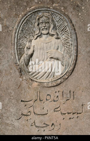 La pierre à tête ancienne montre l'image sculptée de Jésus avec sa main droite, relevée en bénédiction et inscription arabe au cimetière du Patriarcat grec orthodoxe de Jérusalem sur le mont Sion Jérusalem Israël Banque D'Images