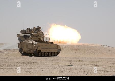 Un M1A2 Abrams char de combat principal engage l'équipage tout en fournissant des cibles de tir d'appui direct pour un élément de reconnaissance au cours de la formation à l'Hunter-Killer Koweït Multipurpose Éventail complexe 7 juin. L'Escadron sabre développe Hunter-Killer comme concept, la collaboration avec les réservoirs de Bradleys both a augmenté la puissance de feu et la vitesse dans la mission de reconnaissance. Banque D'Images