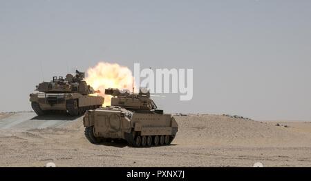 Un M1A2 Abrams char de combat principal engage l'équipage tout en fournissant des cibles de tir d'appui direct pour un élément de reconnaissance au cours de la formation à l'Hunter-Killer Koweït Multipurpose Éventail complexe 7 juin. L'Escadron sabre développe Hunter-Killer comme concept, la collaboration avec les réservoirs de Bradleys both a augmenté la puissance de feu et la vitesse dans la mission de reconnaissance. Banque D'Images
