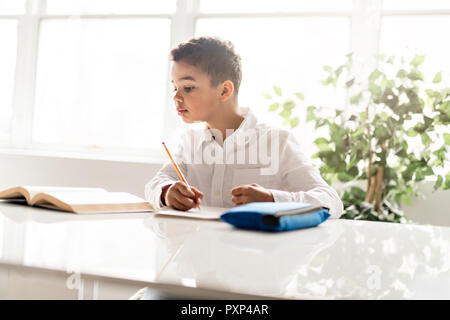 Un mignon petit noir à faire des devoirs à la maison Banque D'Images