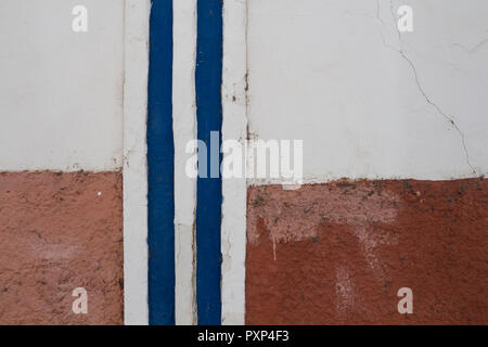 Chambre peinte en rouge et blanc avec un trait vertical bleu et de lignes blanches. Façade plus âgés. Faro, Portugal. Banque D'Images