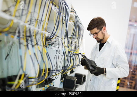 Photo de technicien réseau modems tests en usine Banque D'Images