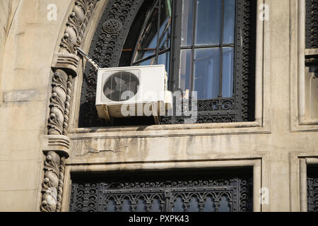 Air conditionné machine sur la façade d'une vieille construction interbelic (période) avec l'horloge, dans un très mauvais état Banque D'Images