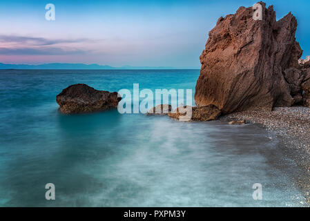 Une longue exposition photograhy à rocky Kato Petres paysage plage au crépuscule. Rhodes, Grèce Banque D'Images