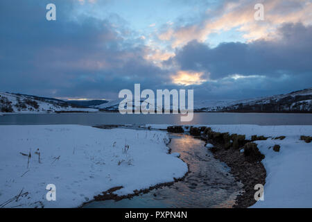 Vue d'hiver de semer l'eau sur un après-midi d'hiver, avec le lac recouvert de glace, et les collines environnantes couvertes de neige Banque D'Images