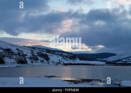 Vue d'hiver de semer l'eau sur un après-midi d'hiver, avec le lac recouvert de glace, et les collines environnantes couvertes de neige Banque D'Images