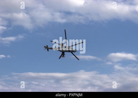 Hélicoptère de combat sur ciel bleu avec des nuages blancs. Vue depuis le bas. Banque D'Images
