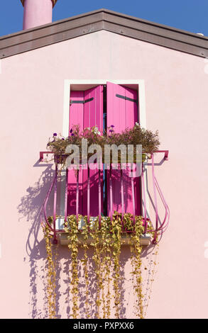 Petit balcon décoré sur une maison de couleur rose Banque D'Images