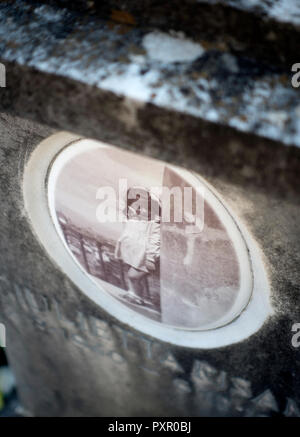 Plaque commémorative sur une pierre tombale dans un cimetière avec l'ancienne image d'un enfant Banque D'Images