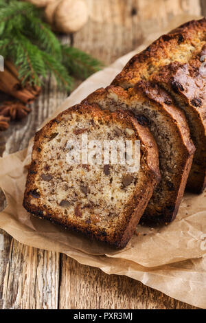 Pain au four gâteau de Noël à la cannelle, noix et fruits secs sur la table rustique de fête Banque D'Images