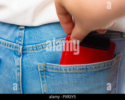 Close-up of a la main de voleur de voler le portefeuille rouge à une femme. Banque D'Images