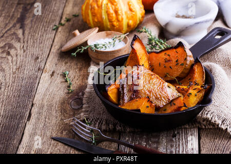 Cuisses de poulet rôti avec des tranches de courge Butternut pumpkin et thym frais Banque D'Images