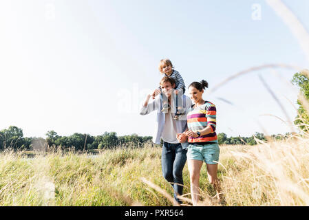 Famille heureuse balade au bord du fleuve sur une belle journée d'été Banque D'Images