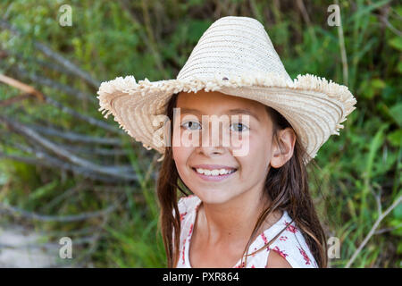 Portrait of smiling girl wearing straw hat outdoors Banque D'Images