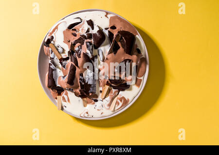 Coupe de glaces en lustre de chocolat fondu dans une assiette Banque D'Images