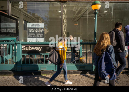 Les banlieusards entrez le métro en face de l'espace de vente au détail, récemment libéré par un salon de manucure, dans le quartier de Chelsea, New York, le vendredi 12 octobre 2018. Les propriétaires sont plus disposés à s'occupe des locataires résultant des loyers plus réaliste et de plus en plus de magasins restent vacants, victime de magasinage en ligne. ( Â© Richard B. Levine) Banque D'Images