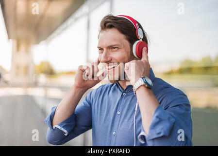 Portrait d'homme heureux d'écouter de la musique avec des écouteurs Banque D'Images