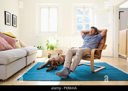 L'homme à la maison avec son chien à ses côtés Banque D'Images