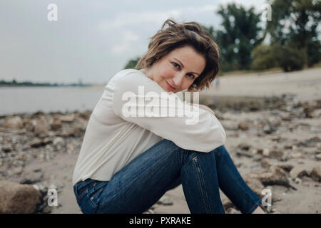 Woman relaxing at the river, looking at camera Banque D'Images