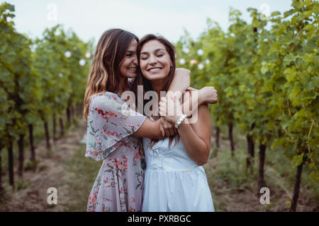 Twin Sisters embrassant à pique-nique estival dans un vignoble Banque D'Images