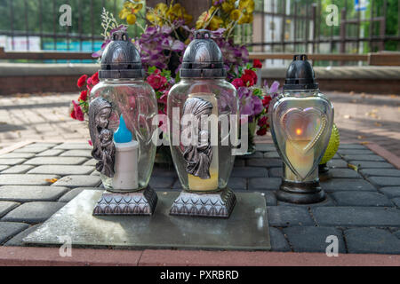 Bougies votives et de fleurs reste sur l'extérieur de l'Église catholique, l'autel Zwoleń, Voïvodie de Mazovie, Pologne Banque D'Images