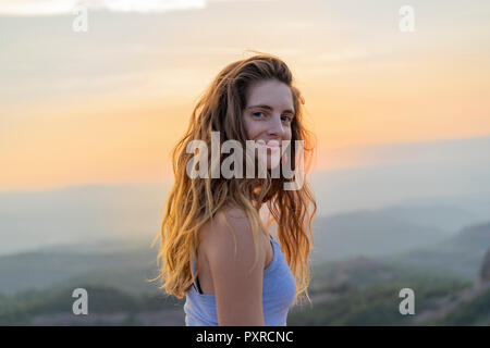 Femme regardant le coucher du soleil dans les montagnes Banque D'Images