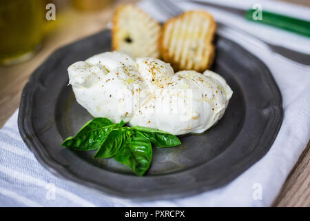 Tresse de mozzarella, basilic et le pain sur la plaque Banque D'Images